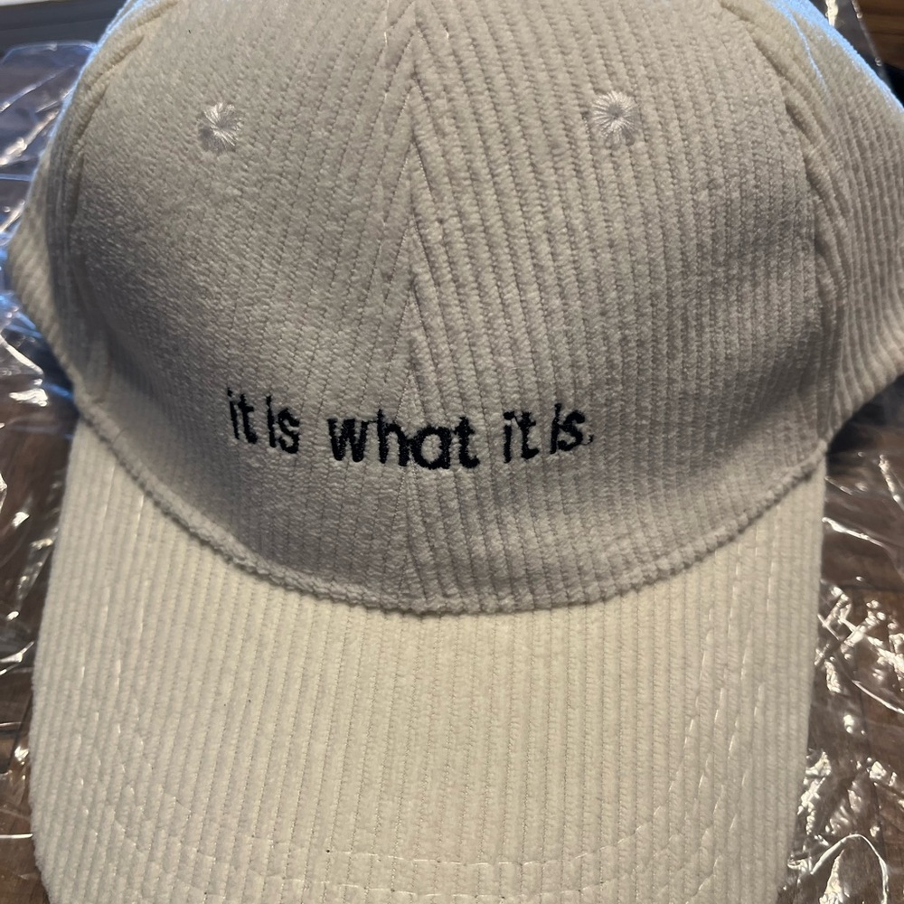 White Corduroy Cap with “It is what it is” embroidery.